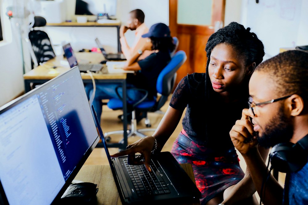 Developers working on software at a shared desk